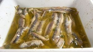 Boquerones o anchoas en vinagre Unos boquerones o anchoas en vinagre, macerando en el aceite de oliva.