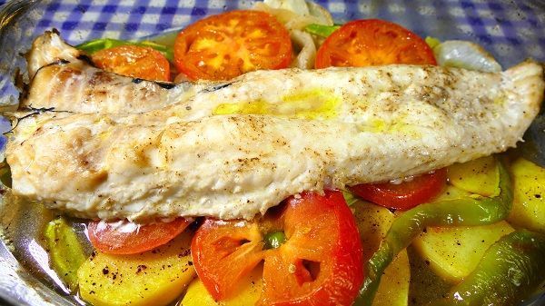 Merluza al horno con verduras. Las verduras se han asado en el mismo horno, junto al pescado