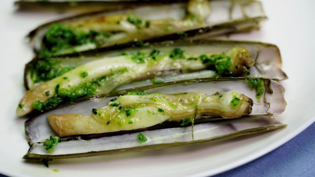 Navajas a la plancha con ajo y perejil. Una receta muy sencilla y muy rápida de hacer en casa. Las navajas son un marisco muy delicioso y muy fácil de encontrar en cualquier supermercado. En esta ocasión lo vamos a cocinar a la plancha aderezándolo con una deliciosa vinagreta de ajo y perejil que le dará un delicioso sabor a toda la elaboración.